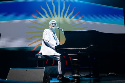 La bandera argentina acompaña a Fito Páez mientras canta "Un vestido y un amor", un momento de alta emotividad en el Movistar Arena