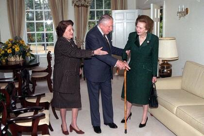 La baronesa Margaret Thatcher, ex primera ministra británica (a la derecha), se reúne con Augusto Pinochet y su esposa Lucía Hiriart (a la izquierda), el viernes 26 de marzo de 1999 en la residencia alquilada del general en Wentworth, Inglaterra, a unos 40 kilómetros de Londres. Dos días antes, el máximo tribunal británico había resuelto que Pinochet no tenía inmunidad absoluta como ex jefe de Estado. Thatcher había apoyado públicamente la liberación del ex dictador, detenido en Londres por una orden de extradición española que buscaba juzgarlo por violaciones a los derechos humanos cometidas durante su gobierno. (Foto: AP/Ian Jones, Pool).