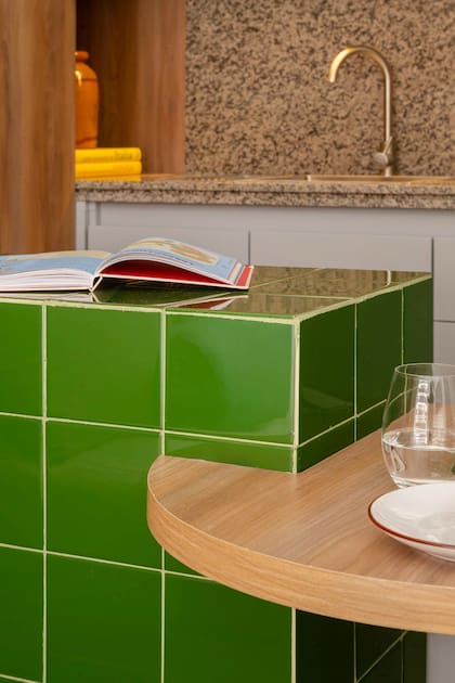 La barra en cerámicos tiene además una mesa encastrada que suma espacio de apoyo y un lugar cómodo para comer.