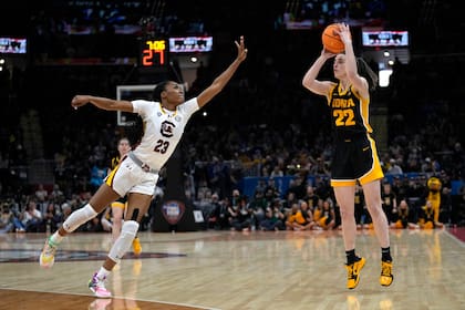 La base de Iowa Caitlin Clark lanza sobre la base de Carolina del Sur Bree Hall en el juego de campeonato del Final Four del baloncesto colegial femenino el domingo 7 de abril del 2024. (AP Foto/Carolyn Kaster)