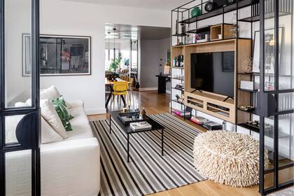 La biblioteca de hierro y roble (Studio VS) aloja una gran TV y varios de los objetos favoritos de los dueños de casa. Obra enmarcada de Viviana Blanco.