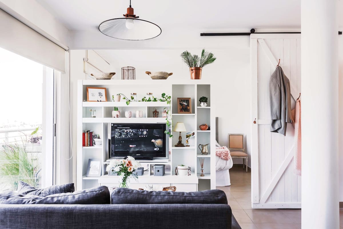 La biblioteca fue el primer mueble que compró: ayuda a organizar los espacios, tener privacidad en el dormitorio y bloquear un poco la luz. Y le hizo una genial base giratoria para el televisor.