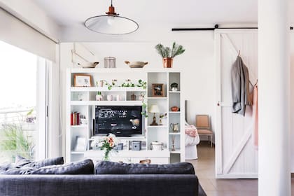 La biblioteca fue el primer mueble que compró: ayuda a organizar los espacios, tener privacidad en el dormitorio y bloquear un poco la luz. Y le hizo una genial base giratoria para el televisor.