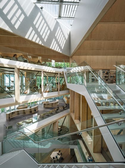La biblioteca se organiza en torno a un amplio patio triangular que conecta los usos a la escalera principal. El vacío de la escalera lleva luz natural a los ambientes y actúa como “chimenea solar” mejorando la ventilación natural.