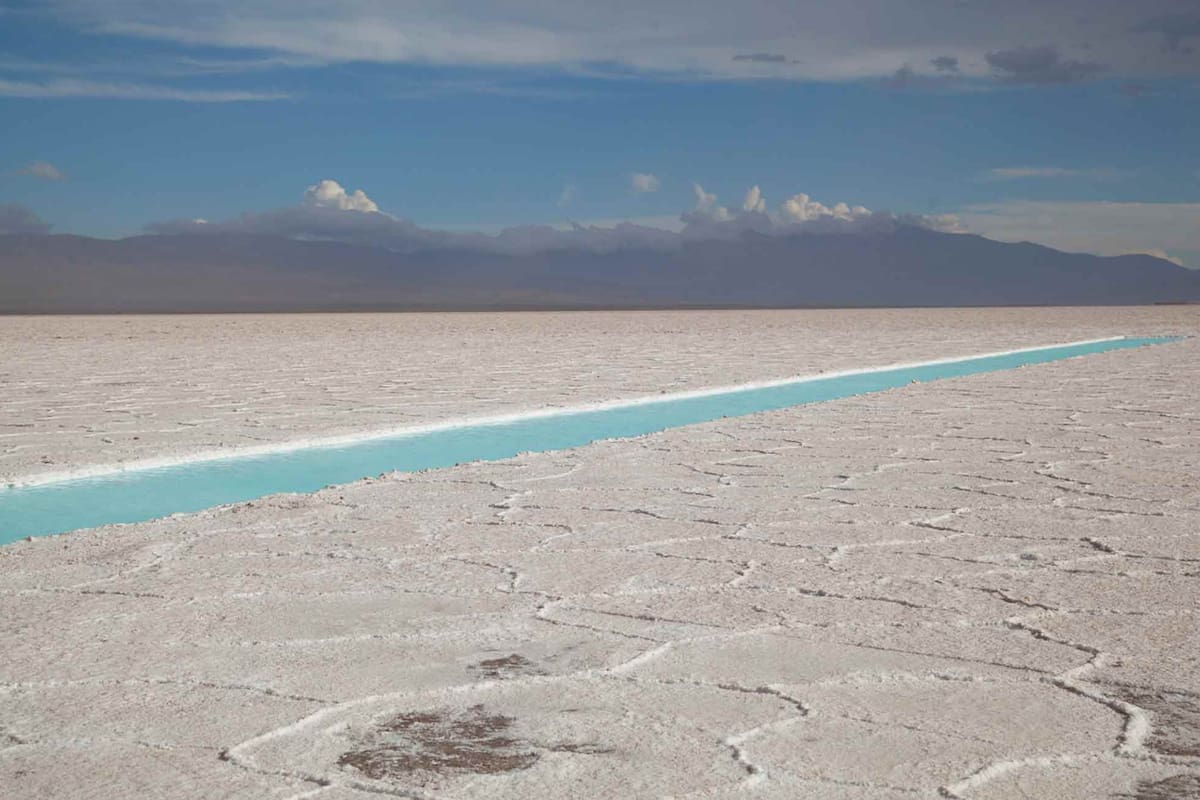 La blancura de las Salinas Grandes atravesada por una laguna de sal.