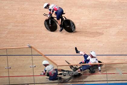 La británica Laura Kenny (27) observa mientras Neah Evans (137) y otra compañera de equipo chocan durante una prueba de ciclismo en pista, en los Juegos de Tokio, el 3 de agosto de 2021, en Izu, Japón. (AP Foto/Christophe Ena)