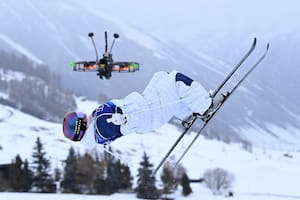 La británica Makayla Gerken Schofield vuela en la prueba de freestyle de esquí y cerca suyo asoma el drone