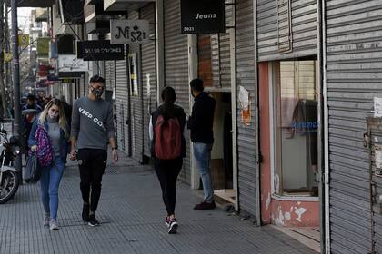 La calle Avellaneda con muy pocos peatones y algunos locales abiertos