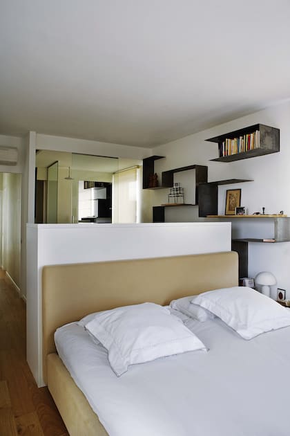 La cama está enfundada en terciopelo claro. Detrás de su alto respaldo, lugar de escritorio, antebaño y paso a la ducha.