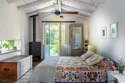 La cama está vestida con una colcha hindú traída de un viaje, almohadones bordados y un manta de lana (ambos de Tienda Barro).