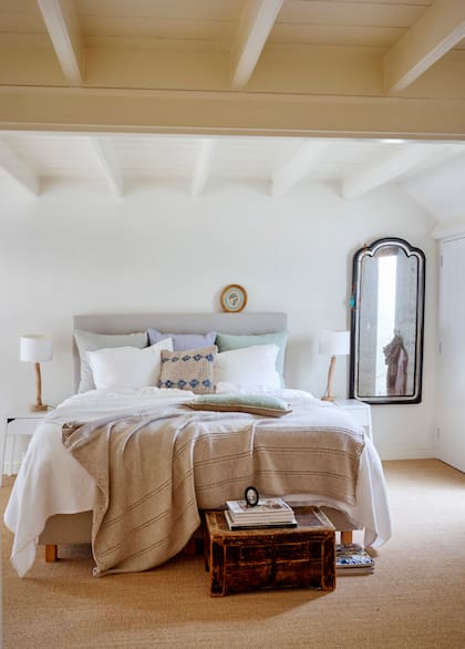 La cama (Ikea) está vestida con mantas y almohadones en colores claros, acordes con la paleta del dormitorio.