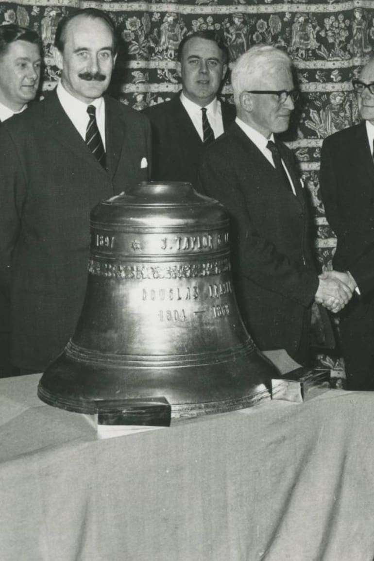 La campana que llegó a la Argentina en 1968 era la original de la fábrica Douglas Fraser & Son, en Escocia; detrás de ella, Hugh Fraser saluda a Roberto Fraser