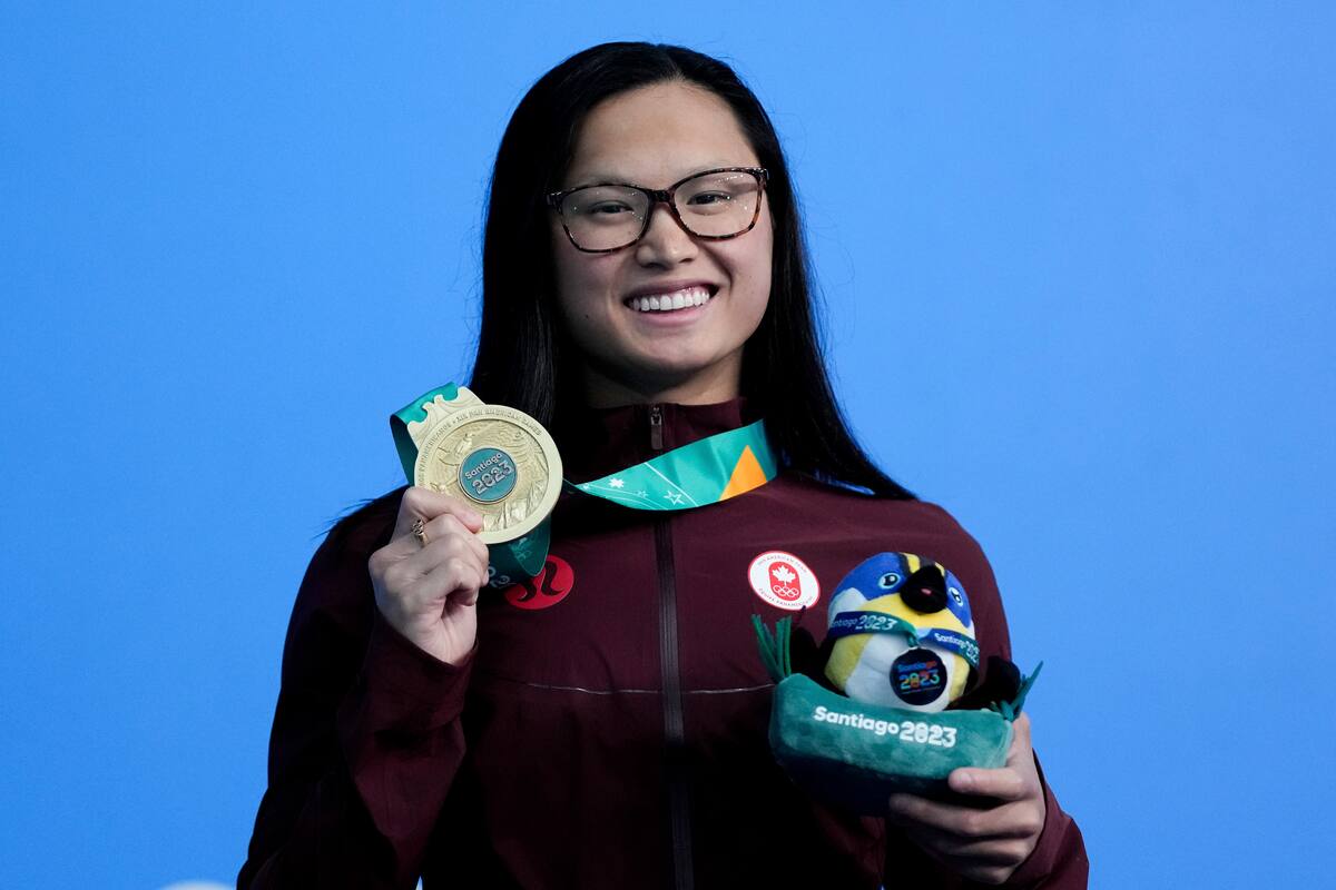 La canadiense Maggie McNeil posa con su medalla de oro tras ganar los 100 metros mariposa en la natación de los Juegos Panamericanos en Santiago, Chile