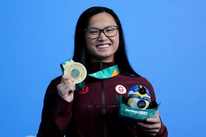 La canadiense Maggie McNeil posa con su medalla de oro tras ganar los 100 metros mariposa en la natación de los Juegos Panamericanos en Santiago, Chile
