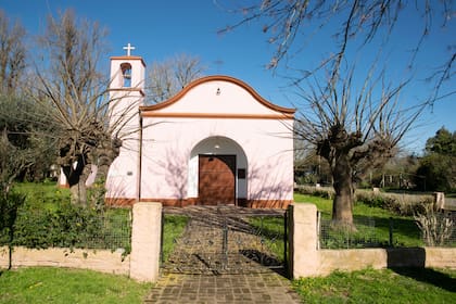 La Capilla Inmaculada Concepción, con su fachada pintada de rosa, de nave central y torre campanario