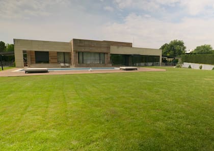 La casa cuenta con un amplio jardín, pileta, gimnasio, sauna y un garaje con espacio para seis vehículos