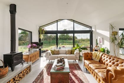 La casa negra se destaca por sus amplios ventanales y su interior luminoso