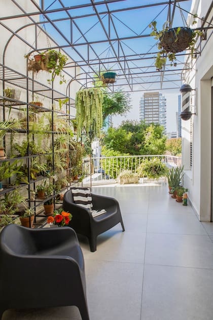 En la terraza, una pérgola de hierro diseñada por los dueños permite colgar plantas y objetos. Sillones ‘Skarpo’ (GardenLife).