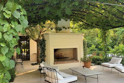 La chimenea permite extender el uso de la galería, cubierta por una parra, cuando el clima es más fresco.