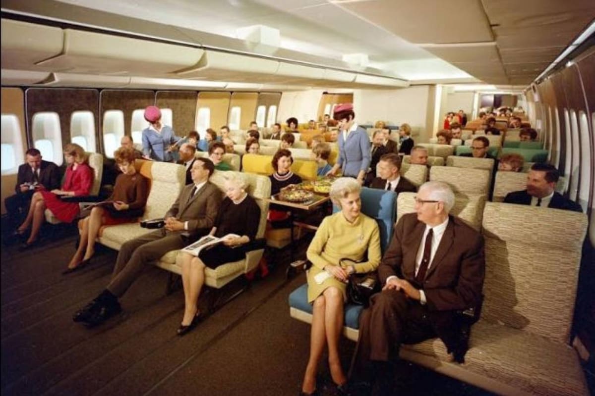 El interior de un Douglas DC-3 y una azafata, en los años previos a la división de los aviones en clases