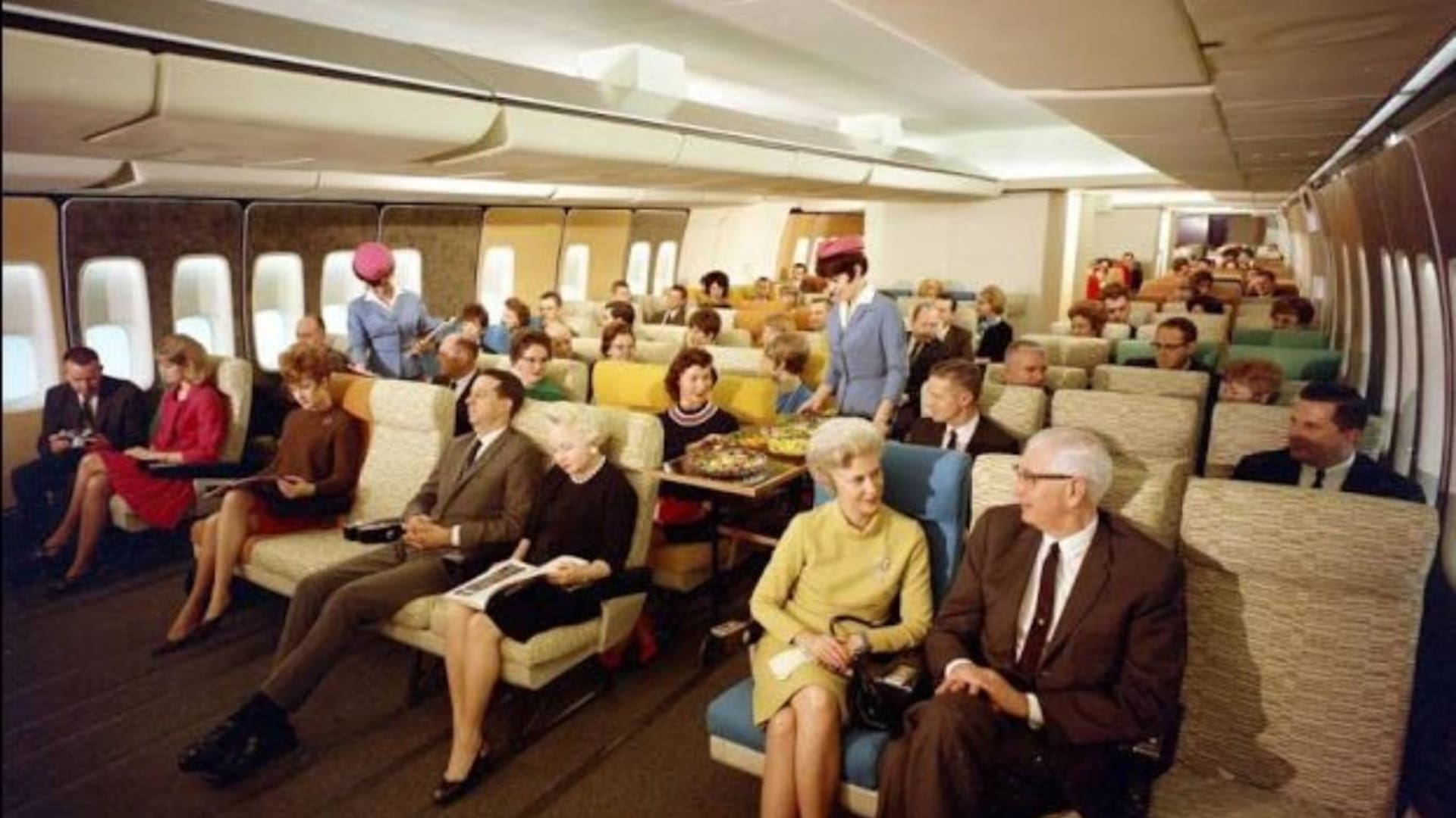 El interior de un Douglas DC-3 y una azafata, en los años previos a la división de los aviones en clases