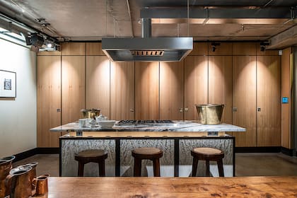 La cocina apuesta al estilo minimalista, y los armarios están ocultos detrás de paneles de madera