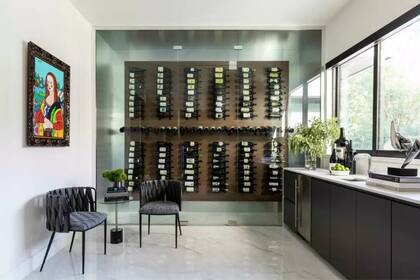 La cocina cuenta con una mesa integrada y una bodega de vinos retroiluminada, detalles que destacan la personalidad del hogar