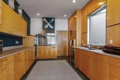 La cocina de estilo galera con alacenas de madera y doble horno.
