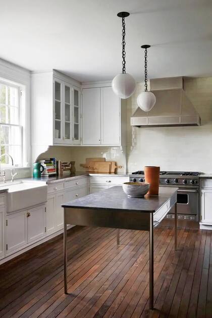 La cocina, en blanco y acero, tiene pisos de madera.