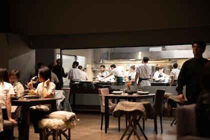 La cocina es a la vista y está separada del salón gris plomo por cristales que dejan ver la brigada de cocineros y asistentes que trabajan muy concentrados y apasionadamente.