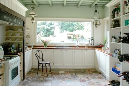 Lo que hace única a la cocina es el trabajo del piso, una cuidadosa combinación de mosaicos calcáreos, y el ventanal, una pantalla al espectáculo diario del jardín.