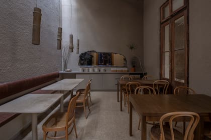 La cocina está expuesta a los comensales a través de un boquete en la pared. Las lámparas de cerámica son creaciones de Flota Objetos (@flota.objetos) y Osis Estudio (@osis.estudio).