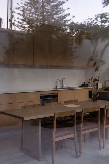 La cocina integra la vegetación exterior a su mobiliario en madera maciza.