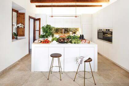 La cocina, integrada al living y con una gran isla. El detalle de los azulejos dorados fue idea de Jordi, el marido de Mima, y fueron confeccionados especialmente en Valencia.