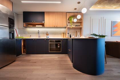 La cocina integrada con el living es imponente, con frente de muebles en Rauvisio Noir (Rehau) que aportan diseño y color.