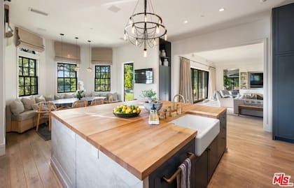 La cocina principal cuenta con una amplia isla central, mobiliario de diseño y pisos de madera natural