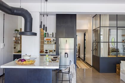 Elementos destacables como el cerramiento, las puertas y el equipamiento de cocina se pintaron en idéntico tono de Pantone "Black Magic".