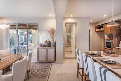 La cocina y el comedor, integrados, también se relacionan con el área social, separados por puertas de vidrio y hierro repartido pintado de un novedoso gris.