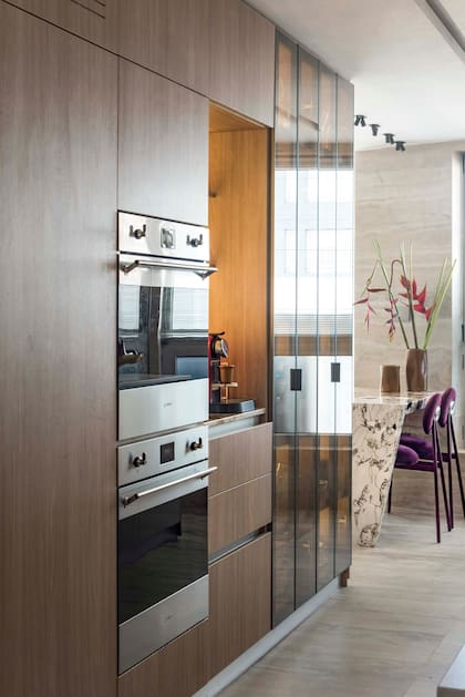 La columna de cocina combina melamina símil madera y puertas de vidrio.