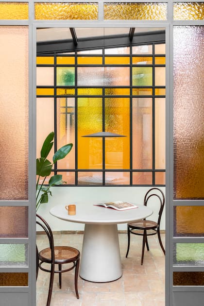La combinación de amarillo, verde y rosa transforma este pequeño comedor en un ambiente íntimo y envolvente.