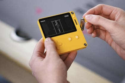 La consola portátil combina un llamativo diseño con una amarilla junto a una manivela y una pantalla para juegos en blanco y negro