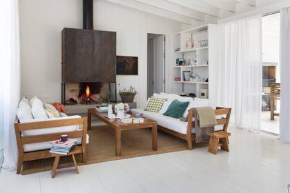 La construcción de madera contempló paredes de material, como la del hogar, que transfiere calor al baño, del otro lado.
