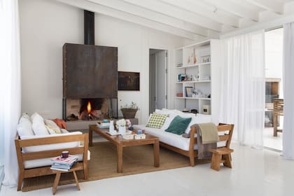 La construcción de madera contempló paredes de material, como la del hogar, que transfiere calor al baño, del otro lado.