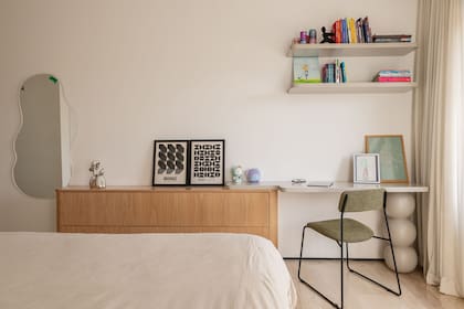 La continuidad entre la cómoda y el escritorio genera una composición única que aprovecha el largo de la pared. Una solución simple y elegante para incorporar un lugar de trabajo dentro del dormitorio.