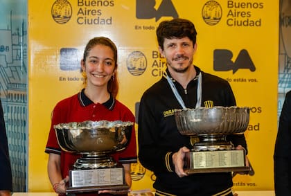La copa que había levantado en otras siete ocasiones ahora agregará por octava vez el nombre de Diego Flores, que sonríe junto a la campeonata del Argentino femenino, Ernestina Adam.