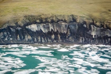 La costa de la península de Bykovsky en el centro del Mar de Laptev, Siberia se retira durante el verano, cuando los bloques de hielo permafrost caen a la playa y son erosionados por las olas. Crédito: P. Overduin