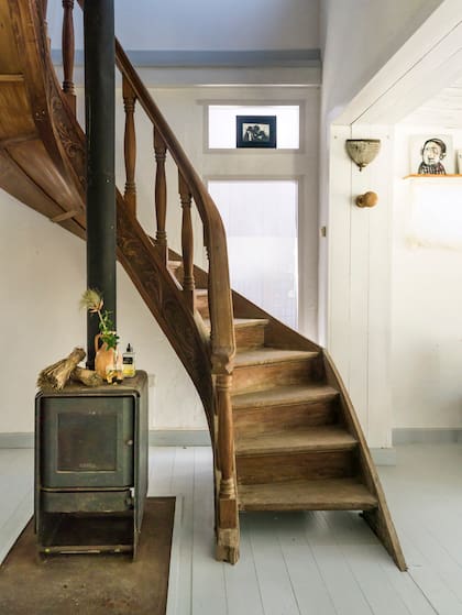 La decisión de pintar pisos y techos de blanco ayuda a resaltar la escalera.