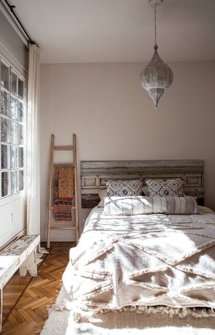 La deco es simple y cálida: pocos muebles, un respaldo hecho con molduras recuperadas y textiles suaves al tacto, como la alfombra artesanal (Al telar).
