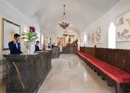 La decoración interior mantiene algunos guiños a la antigua vida de convento, como estas banquetas en la recepción.