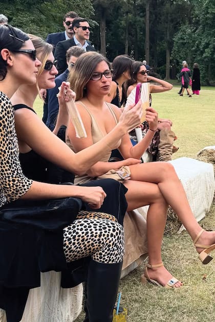 La diseñadora Luna Álvarez Castillo, con total look de estampa animal y botas de caña alta, siguió la ceremonia con primas y amigas, todas sentadas en los fardos que hicieron de bancos.